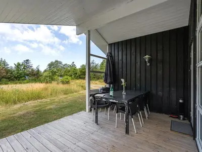 a patio with a table and chairs on a deck at Holiday Home Anahi - 3km from the sea by Interhome in Blokhus
