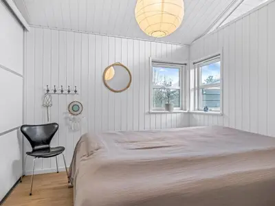 a bedroom with a bed and a chair in it at Holiday Home Onta - 900m from the sea by Interhome in Blokhus