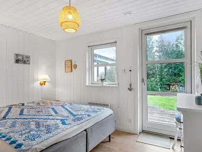 a bedroom with a bed and two windows at Holiday Home Onta - 900m from the sea by Interhome in Blokhus