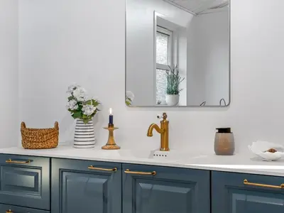 a bathroom with blue cabinets and a sink with a mirror at Holiday Home Onta - 900m from the sea by Interhome in Blokhus