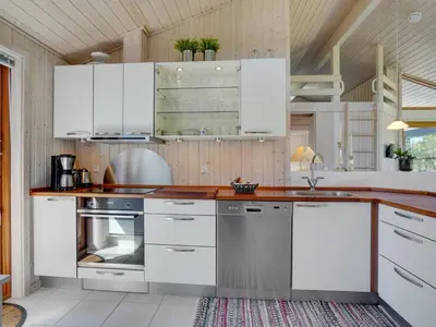 a kitchen with white cabinets and stainless steel appliances at Holiday Home Jelin - 2-5km from the sea by Interhome in Blokhus
