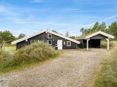 a black barn with a white door at Holiday Home Helene - 1-5km from the sea by Interhome in Blokhus