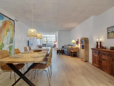 a dining room and living room with a table and chairs at Holiday Home Klaudius - 2km from the sea by Interhome in Blokhus