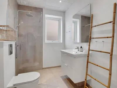 a bathroom with a toilet and a sink and a shower at Holiday Home Klaudius - 2km from the sea by Interhome in Blokhus