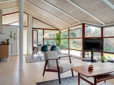 a living room with a television and a table at Holiday Home Angja - 800m from the sea by Interhome in Blokhus