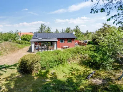 a red house with a black roof on a hill at Holiday Home Lykka - 950m from the sea by Interhome in Blokhus