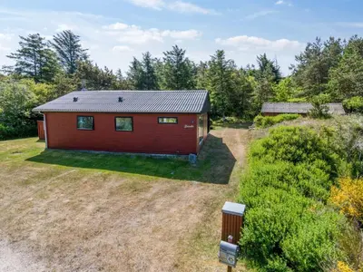an aerial view of a red cabin in the woods at Holiday Home Lykka - 950m from the sea by Interhome in Blokhus