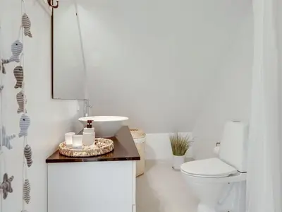 a bathroom with a white toilet and a sink at Holiday Home Riki - 150m from the sea by Interhome in Blokhus