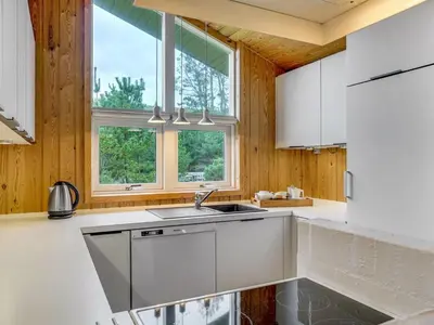 a kitchen with a sink and two windows at Holiday Home Hereth - 700m from the sea by Interhome in Saltum