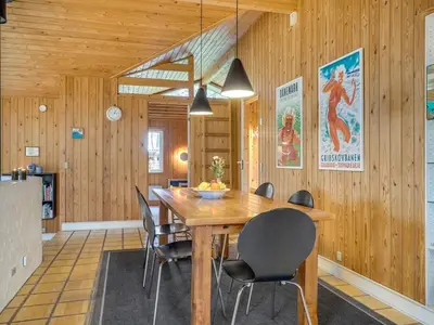 a dining room with a wooden table and chairs at Holiday Home Hereth - 700m from the sea by Interhome in Saltum