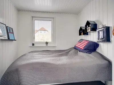 a bed in a white room with a window at Holiday Home Kiina - 100m from the sea by Interhome in Blokhus