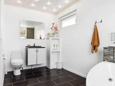 a bathroom with a toilet and a sink at Holiday Home Gerwin - 3km from the sea by Interhome in Blokhus