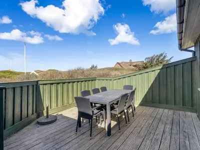 a patio with a table and chairs on a deck at Holiday Home Jobst - 150m from the sea by Interhome in Saltum