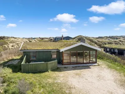 a green house with a grass roof on a hill at Holiday Home Jobst - 150m from the sea by Interhome in Saltum