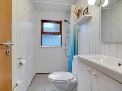 a white bathroom with a toilet and a sink at Holiday Home Jobst - 150m from the sea by Interhome in Saltum