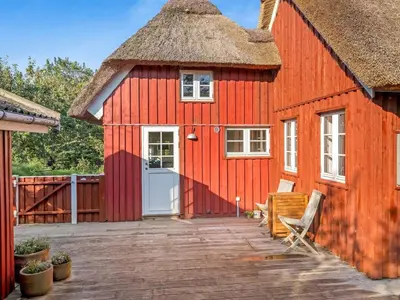 a red barn with a thatched roof at Holiday Home Beghel - 350m from the sea by Interhome in Blokhus