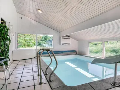 a swimming pool in a house with a ceiling at Holiday Home Nilson - 1-4km from the sea by Interhome in Blokhus