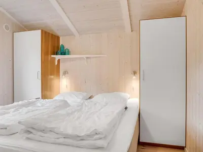 a bedroom with a white bed with two white pillows at Holiday Home Barnet - 2-2km from the sea by Interhome in Blokhus