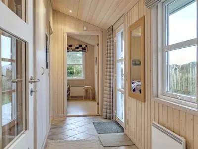 a hallway with wood paneled walls and windows at Holiday Home Sighwarth - 350m from the sea by Interhome in Saltum