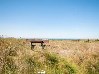 a bench sitting in the middle of a field at Holiday Home Diuri - 400m from the sea by Interhome in Saltum