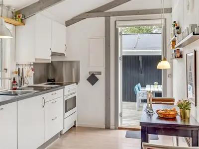 a kitchen with white cabinets and a door to a patio at Holiday Home Eivy - 1km from the sea by Interhome in Saltum