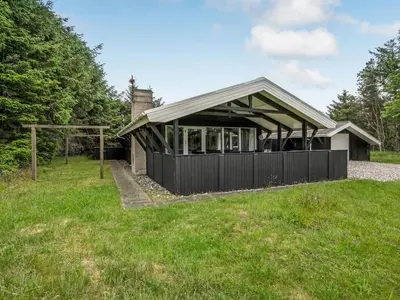a house with a gambrel roof in a field at Holiday Home Eivy - 1km from the sea by Interhome in Saltum