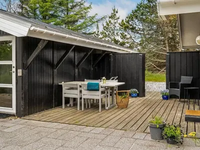 a wooden deck with a table and chairs on it at Holiday Home Eivy - 1km from the sea by Interhome in Saltum
