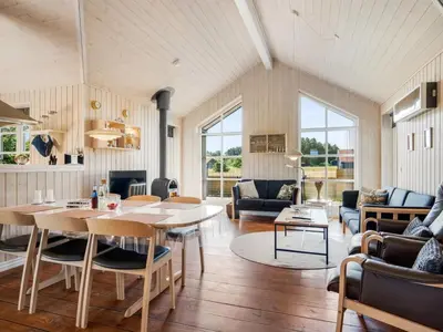 a living room with a table and chairs at Holiday Home Annemie - 1-8km from the sea by Interhome in Saltum