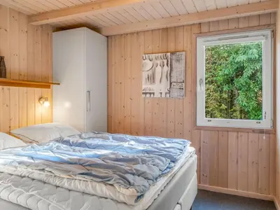 a bedroom with a large bed and a window at Holiday Home Mechthild - 2-7km from the sea by Interhome in Saltum