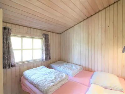 two beds in a room with a window at Holiday Home Arita - 250m from the sea by Interhome in Saltum