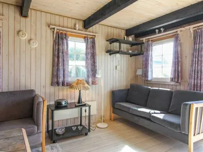 a living room with two couches and two windows at Holiday Home Arita - 250m from the sea by Interhome in Saltum