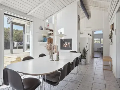 a white dining room with a white table and chairs at Holiday Home Dijana - 150m from the sea by Interhome in Saltum