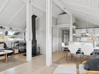 a living room and dining room with a table and chairs at Holiday Home Allida - 800m from the sea by Interhome in Saltum