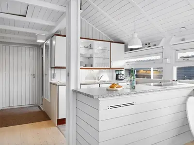 a kitchen with white cabinets and a counter top at Holiday Home Allida - 800m from the sea by Interhome in Saltum