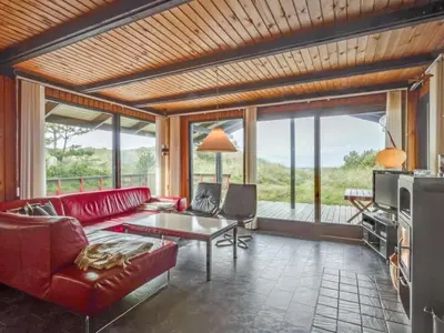 a living room with a red couch and a table at Holiday Home Maini - 600m from the sea by Interhome in Saltum