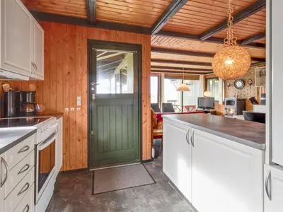 a kitchen with white cabinets and a green door at Holiday Home Maini - 600m from the sea by Interhome in Saltum