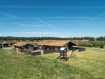 a group of buildings with a grass field at Holiday Home Dorothe - 1-4km from the sea by Interhome in Saltum