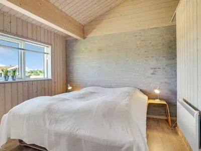 a bedroom with a white bed and a window at Holiday Home Dorothe - 1-4km from the sea by Interhome in Saltum