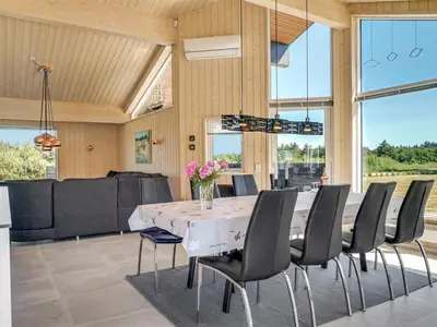 a dining room with a white table and chairs at Holiday Home Dorothe - 1-4km from the sea by Interhome in Saltum