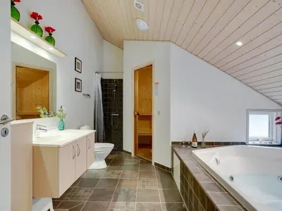 a bathroom with a tub and a toilet and a sink at Holiday Home Alhed - 650m from the sea by Interhome in Saltum