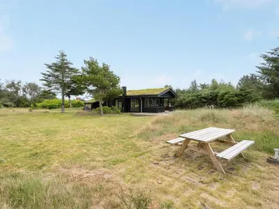 a picnic table in front of a house at Holiday Home Jorek - 1-3km from the sea by Interhome in Saltum