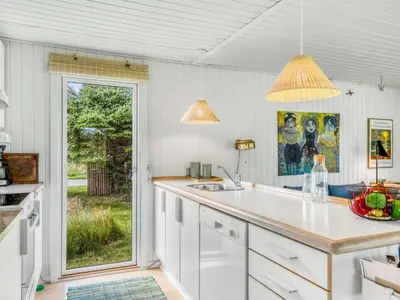 a kitchen with white cabinets and a sink and a window at Holiday Home Jorek - 1-3km from the sea by Interhome in Saltum