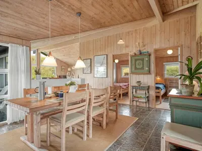 a kitchen and dining room with a table and chairs at Holiday Home Rosemari - 260m from the sea by Interhome in Saltum