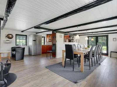 a dining room and living room with a table and chairs at Holiday Home Iben - 2-3km from the sea by Interhome in Saltum