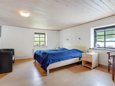 a bedroom with a bed with a blue blanket at Holiday Home Iben - 2-3km from the sea by Interhome in Saltum