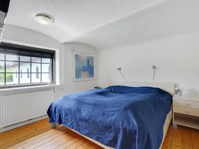 a bedroom with a blue bed and a window at Holiday Home Iben - 2-3km from the sea by Interhome in Saltum