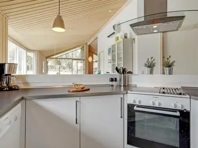 a kitchen with white cabinets and a stove top oven at Holiday Home Frerich - 1-5km from the sea by Interhome in Saltum