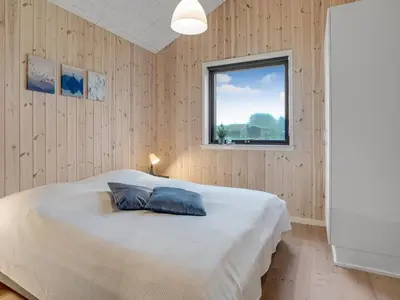 a bedroom with a bed with a pillow on it at Holiday Home Carla - 1-5km from the sea by Interhome in Saltum