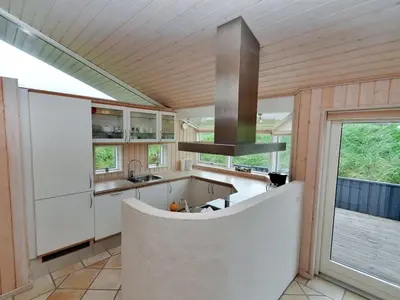a kitchen with white cabinets and a stainless steel hood at Holiday Home Hadar - 100m from the sea by Interhome in Saltum