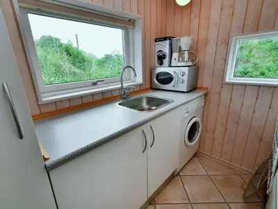a kitchen with a sink and a microwave at Holiday Home Hadar - 100m from the sea by Interhome in Saltum